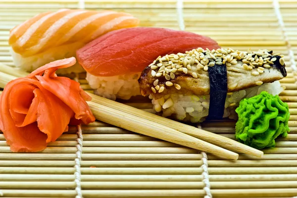 寿司鳗鱼金枪鱼和三文鱼配芥末姜和筷子 图库图片