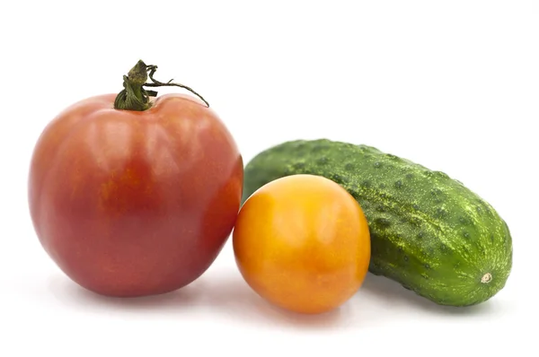 A tomates biologiques rouges et jaunes à côté d'un concombre — Photo
