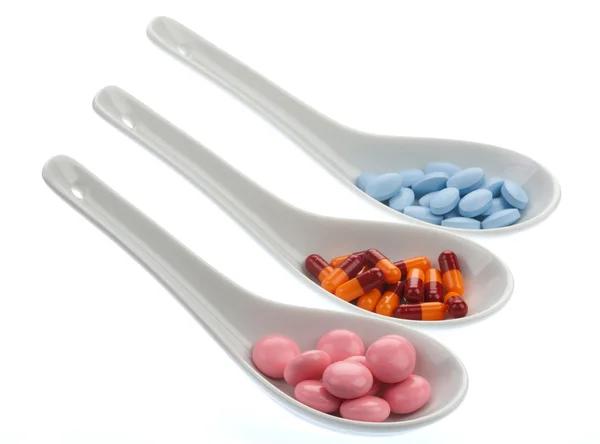 Tres cucharas de cerámica con píldoras de colores — Foto de Stock