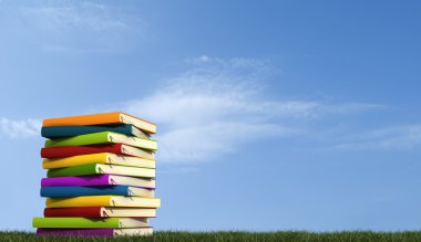 A stack of books over grass