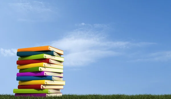 A stack of books over grass — Stock Photo, Image