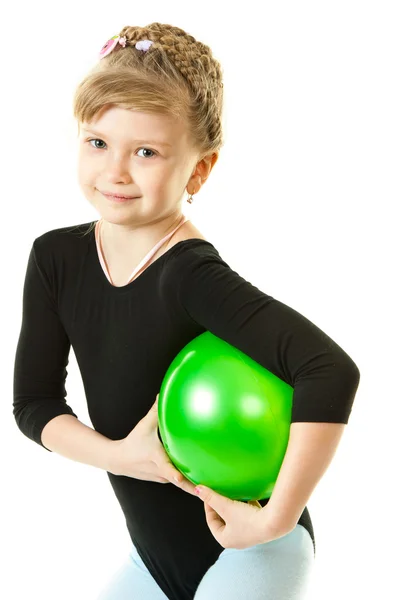 En flicka som leker med en grön boll — Stockfoto