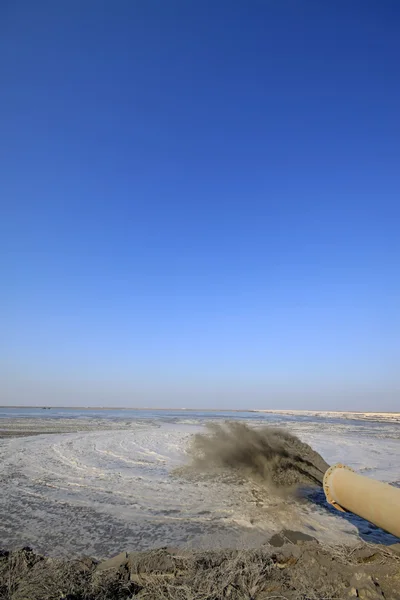 Soplando arena hecha ingeniería de tierra junto al mar —  Fotos de Stock