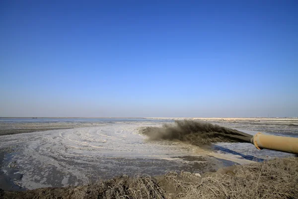 Soplando arena hecha ingeniería de tierra junto al mar — Foto de Stock