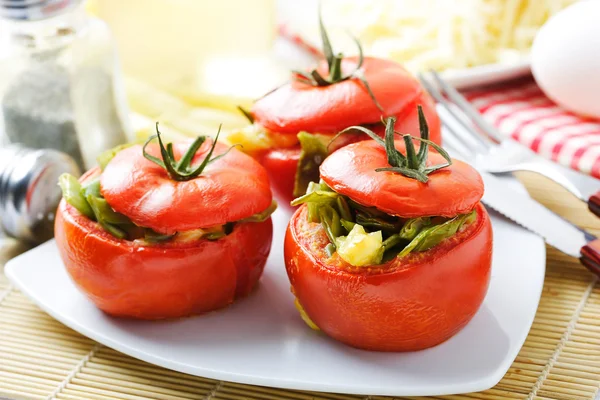 緑の野菜とチーズを詰めた焼きトマト添え ストック画像