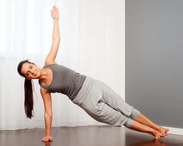 Mulher praticando ioga no quarto — Fotografia de Stock