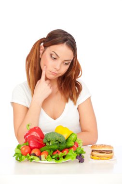 Woman choicing burger or vegetables clipart