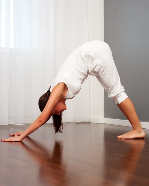 Mulher fazendo exercícios de alongamento no quarto — Fotografia de Stock