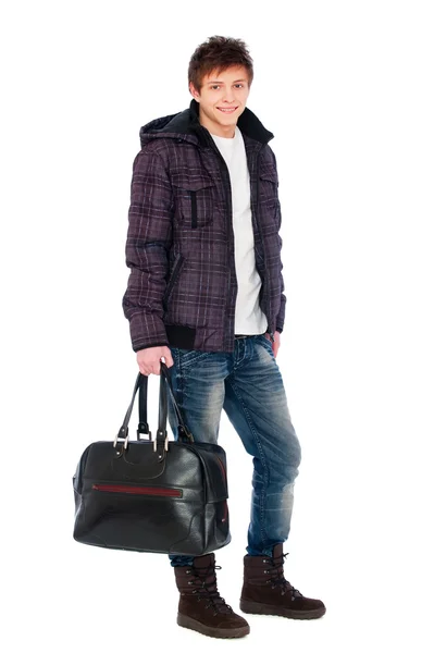 Young man in coat holding bag — Stock Photo, Image