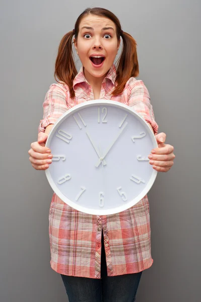 Scared woman showing wall clock Stock Photo