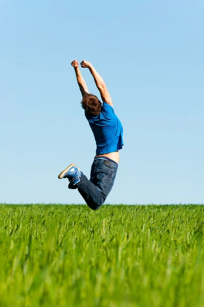 Άνθρωπος πηδώντας στο πράσινο πεδίο — Φωτογραφία Αρχείου