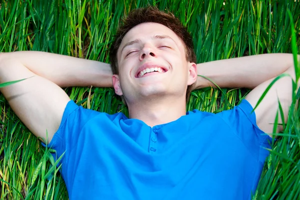 躺在绿草地上的男人 — 图库照片