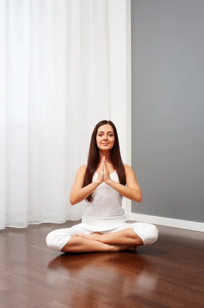 Mulher sorridente fazendo ioga no quarto — Fotografia de Stock