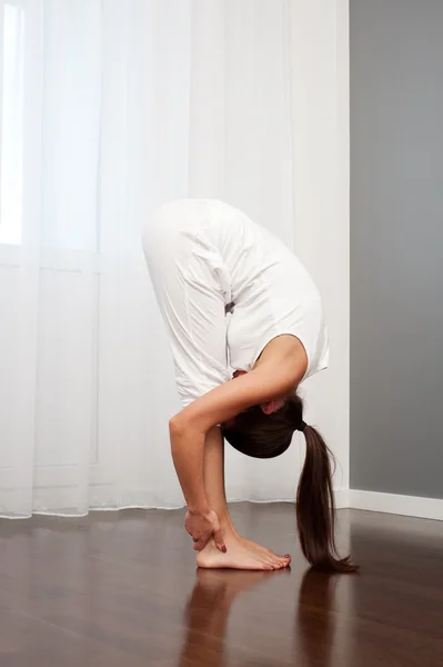 Mujer haciendo ejercicio de flexibilidad en la habitación —  Fotos de Stock