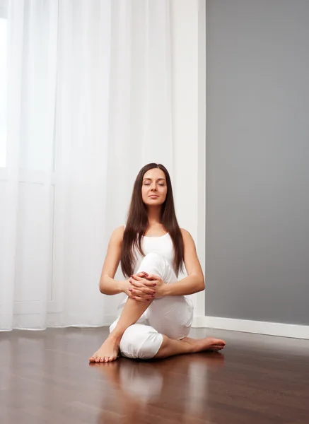 Vrouw doet yoga oefening op de vloer — Stockfoto
