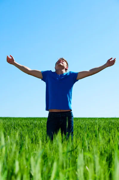 Homem feliz em pé no prado verde — Fotografia de Stock