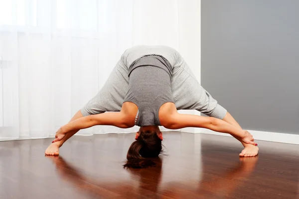 Mujer haciendo ejercicios de flexibilidad en la habitación — Stockfoto