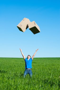 Man catching boxes on green field clipart