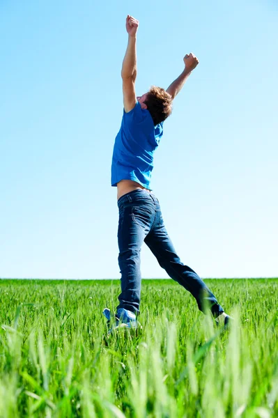 Hombre saltando en el campo verde —  Fotos de Stock