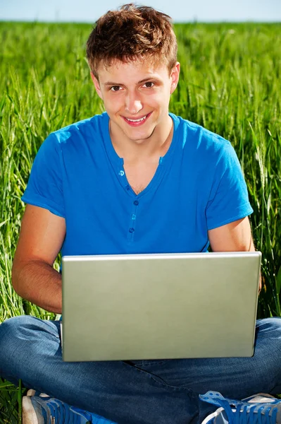 Chico sonriente con computadora — Foto de Stock