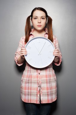 Young woman holding wall clock