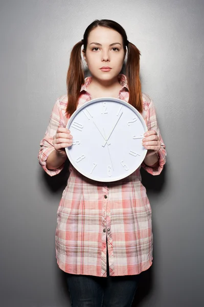 壁の時計を保持している若い女性 — ストック写真