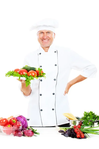 Smiley chef holding lemez, friss zöldségekkel — Stock Fotó