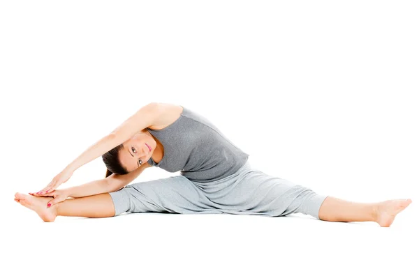 Young woman doing stretch exercise on floor — Stok fotoğraf