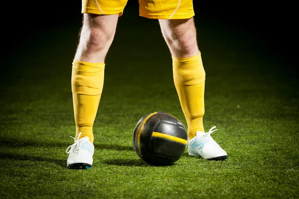 Pallone da calcio e piedi di un giocatore di calcio — Foto Stock