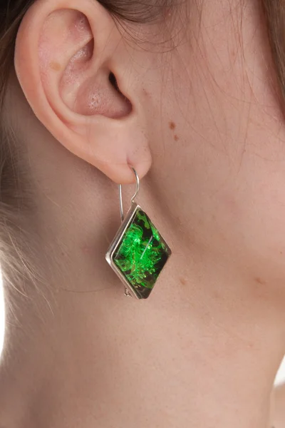 Amber earring op vrouwelijke oor. — Stockfoto
