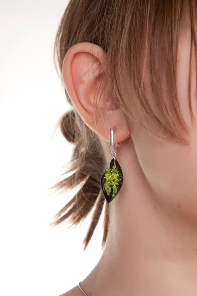 Amber earring op vrouwelijke oor. — Stockfoto