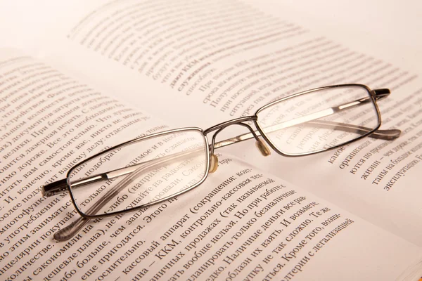 Brille auf dem Hintergrund ein aufgeschlagenes Buch. — Stockfoto