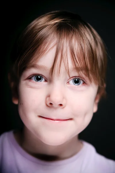Retrato de uma criança em um fundo preto . — Fotografia de Stock