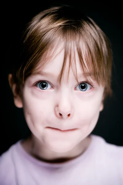 Retrato de uma criança em um fundo preto . — Fotografia de Stock
