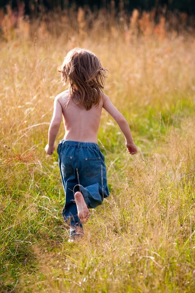 Un enfant courant le long d'un chemin dans le champ — Photo