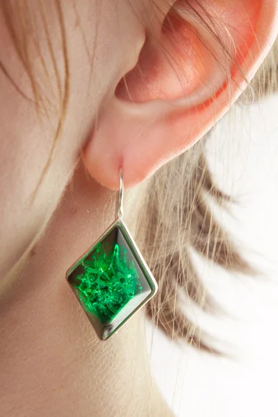 Amber earring on female ear. — Stock Photo, Image