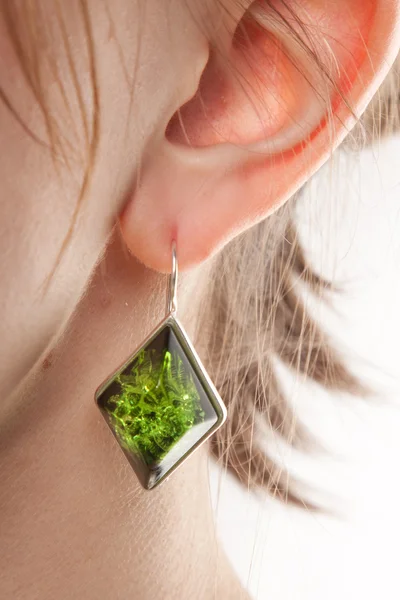 Amber earring on female ear. — Stock Photo, Image