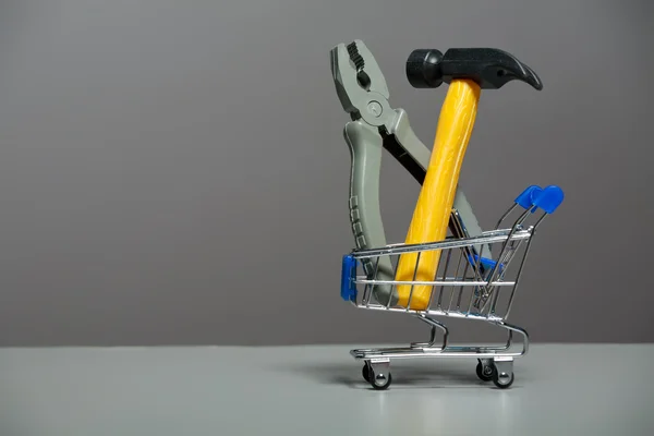 Shopping carts with a hammer and pliers — Stock Photo, Image