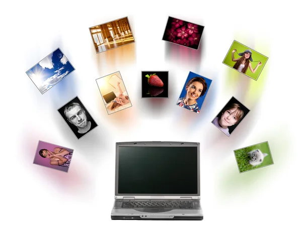 stock image A laptop and digital pictures flying.