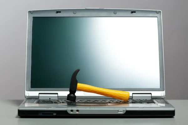 Ноутбук с молотком на экране — стоковое фото