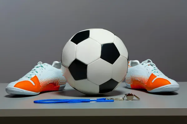 Спортивная концепция - обувь, футбольный мяч и свисток . — стоковое фото