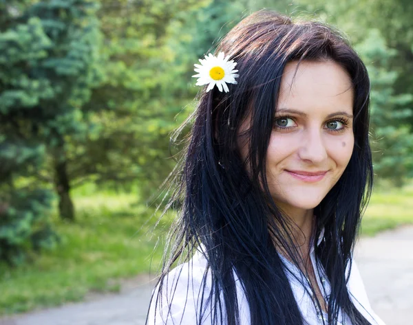 Vackra leende kvinna med blomma — Stockfoto