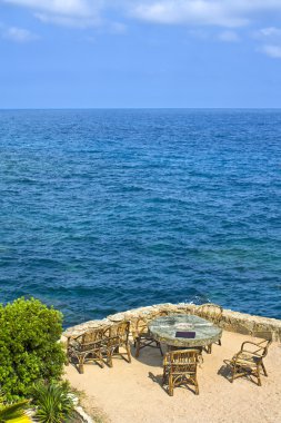 Mesa y sillas frente al mar en Lloret de Mar, Cataluña, España clipart