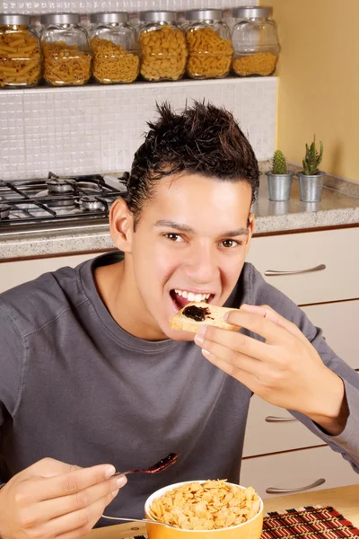 Młody człowiek je śniadanie w domu — Zdjęcie stockowe
