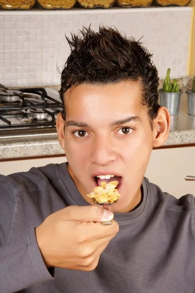 Młody człowiek jeść płatki kukurydziane — Zdjęcie stockowe