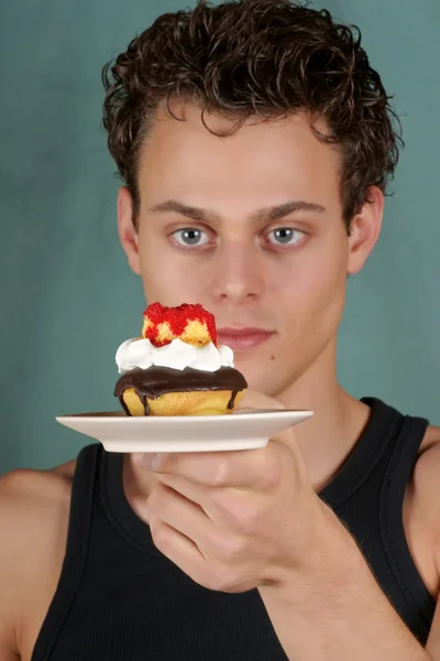 Young man with cupcake — Stock Photo, Image