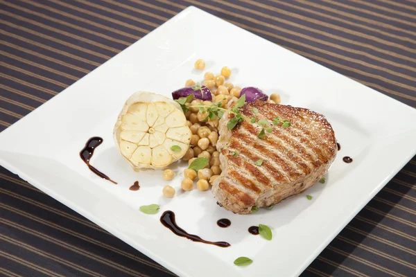 Grilled pork chop w peas and garlic — Stock Photo, Image