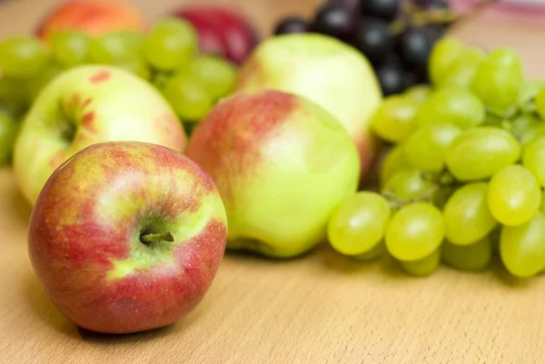 Fresh fruits, apples, grapes and peaches on the table — Stock Photo, Image