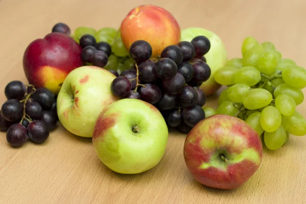 Świeżych owoców, jabłka, winogron i brzoskwinie na stole — Zdjęcie stockowe