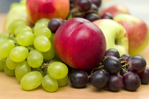 Frutos frescos, maçãs, uvas e pêssegos em cima da mesa — Fotografia de Stock